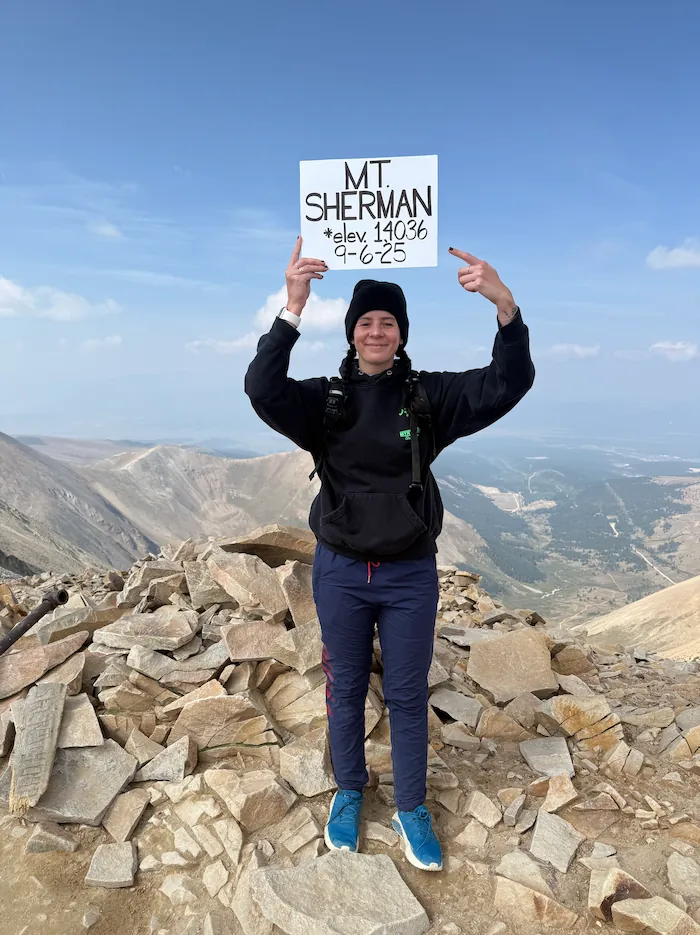 Jess celebrating a hike to the summit of Mount Sherman